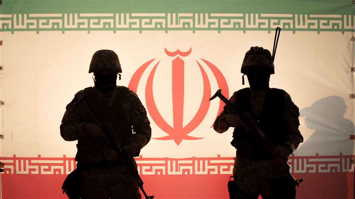 <i>Morteza Nikoubazl/NurPhoto/Getty Images</i><br/>Two Islamic Revolutionary Guard Corps (IRGC) armed military personnel stand in front of an Iran flag during a pro-government protest rally in southern Tehran