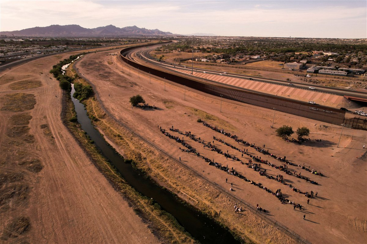 <i>Jose Luis Gonzalez/Reuters</i><br/>Migrants stand near the border wall after crossing the Rio Bravo river with the intention of turning themselves in to the U.S. Border Patrol agents