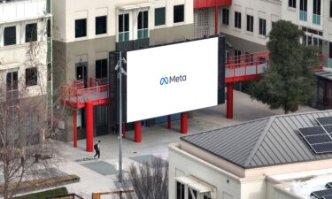 A worker walks by a large video monitor on the Meta campus on February 02