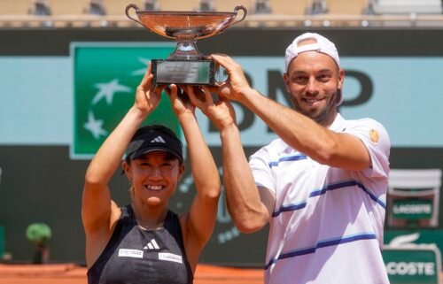 Japan's Miyu Kato and Tim Puetz hold the trophy after winning the mixed doubles final at the French Open.