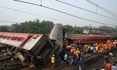 Policemen stand guard at the site where the trains derailed