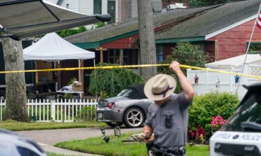 Authorities work outside as they search the home of suspect Rex Heuermann