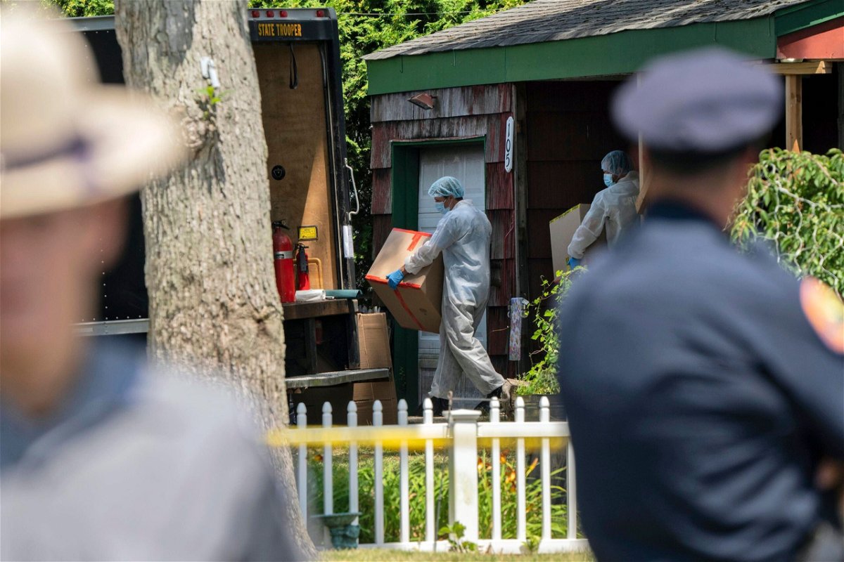 Crime laboratory officers remove boxes as law enforcement searches the home of Rex Heuermann