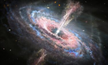 An artist's illustration shows a distant galaxy with an active quasar at its center. A quasar is exceptionally bright because it releases tons of energy that's generated as a supermassive black hole gobbles up gas