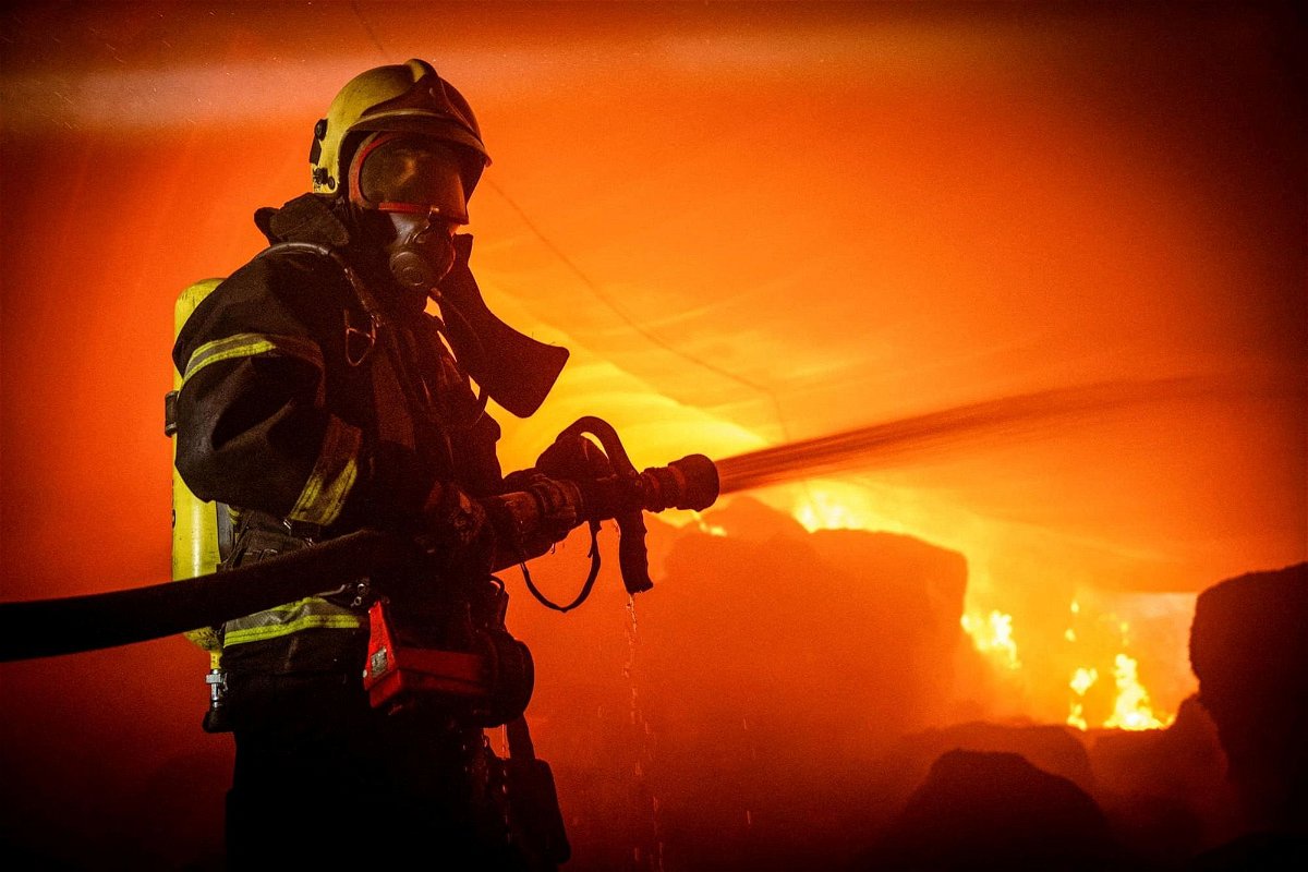 A firefighter works at a site of storage facilities hit during Russian missile and drone strikes