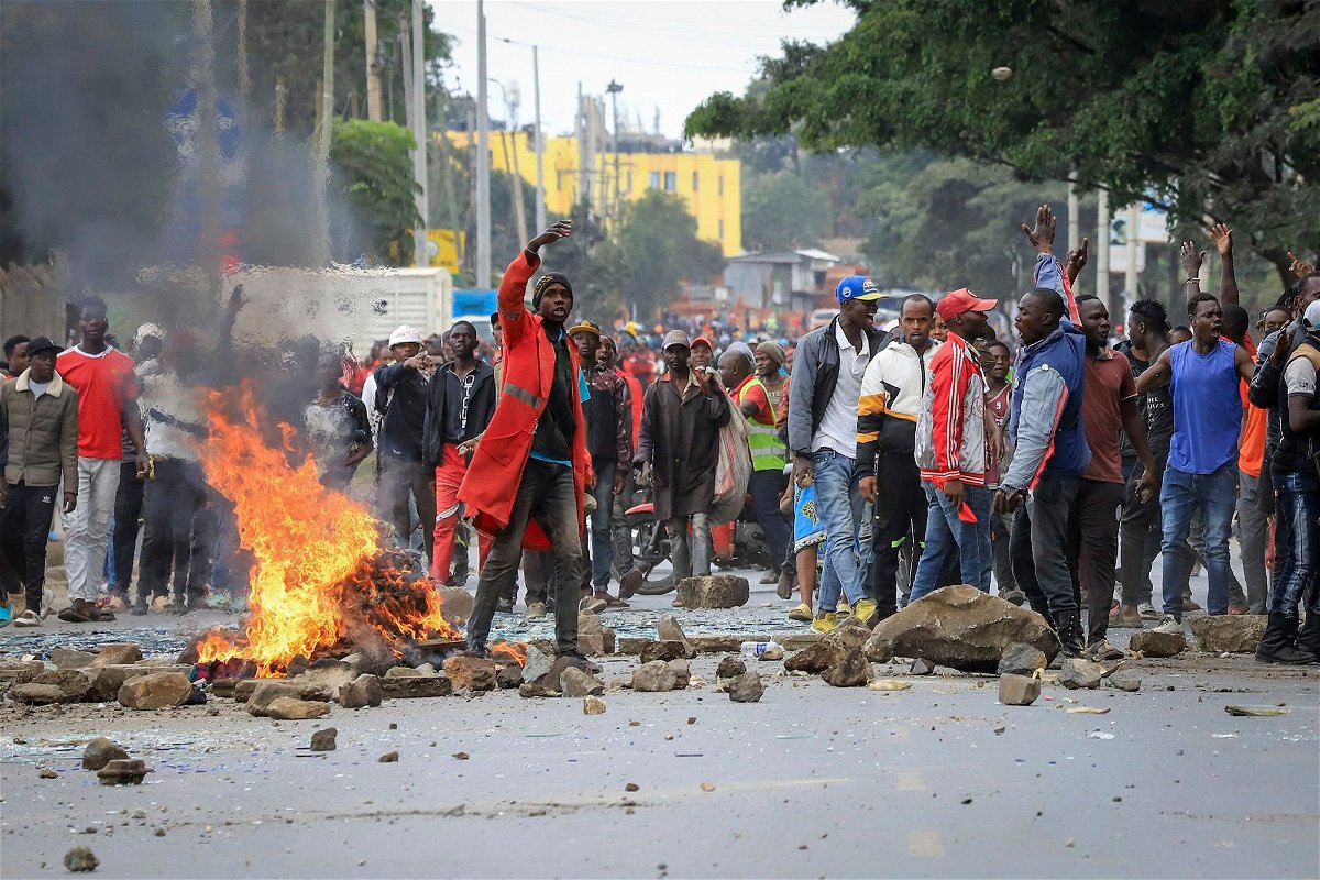 Protesters stand by a burning barricade on a street in the Mathare neighborhood of Nairobi