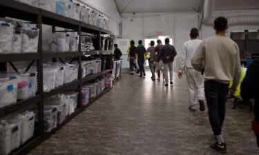 Migrants walk through a newly opened U.S. Customs and Border Protection soft-sided facility in El Paso