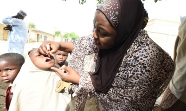 A health official tries to immunize a child during a vaccination campaign in Kano