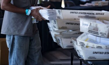 An election worker processes absentee ballots at State Farm Arena on November 2