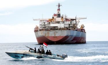 A Yemeni coast guard boat sails past the FSO Safer vessel at Ras Issa port in Hodeidah province