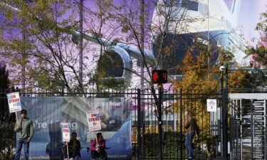 Boeing factory workers hold signs on the picket line outside the Boeing manufacturing facility in this October 24 file photo