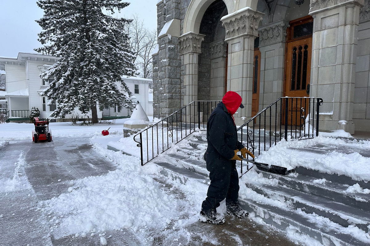 A man shovels snow outside a church in Lowville